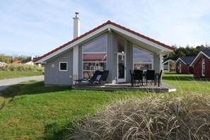 A modern single-story house with a covered patio and a chimney. - Familienversteck für 6 in Großenbrode (Großenbrode)