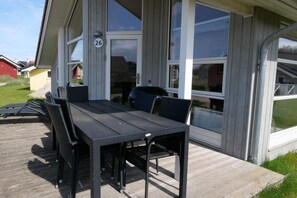 A patio with a table and chairs, a number 26 sign, and a view of the surrounding area. - Wellness-Oase mit Alkovenbett (Großenbrode)