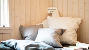 Sänky, jossa on tyynyjä, ja sen yläpuolella oleva kyltti.
