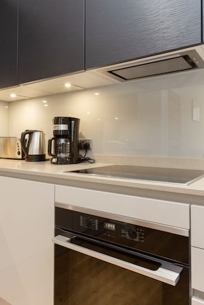 Een moderne keuken met een inbouwvaatwasser, koffiezetapparaat en broodrooster.
