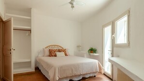 A bedroom with a bed, a ceiling fan, a window, and a radiator. - Villa Marina, an authentic Mediterranean home overlooking the sea of Villasimius (VILLASIMIUS)