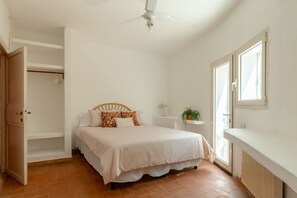 A bedroom with a bed, a ceiling fan, a window, and a radiator. - Villa Marina, an authentic Mediterranean home overlooking the sea of Villasimius (VILLASIMIUS)