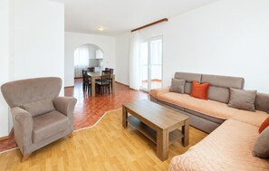 Ein Wohnzimmer mit einer Couch, einem Sessel und einem Holztisch.