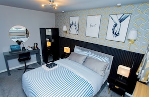 Une chambre d’hôtel avec un lit, un bureau et un miroir.