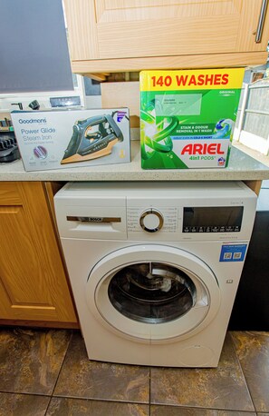Een Bosch wasmachine met voorlader, een bedieningspaneel en een deur.