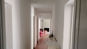 A corridor with a tiled floor, white walls, and a door at the end. - House in the Provençal countryside (Le Thoronet)