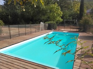 A rectangular swimming pool with a wooden deck surrounding it. - House in the Provençal countryside (Le Thoronet)