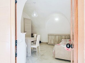 A room with a bed, a desk, a chair, and a hanging light fixture. - Majella Living by Interhome (Caramanico Terme)