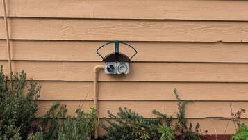 A utility meter attached to a beige wooden house siding.