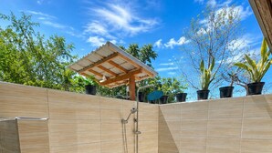 A small, enclosed bathroom with a shower, toilet, and tiled walls. - Cozzy Bilva Garden (Klungkung)