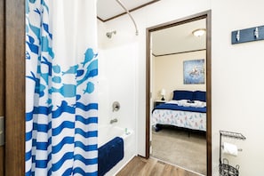 A bathroom with a shower curtain, a bathtub, and a toilet. - Main lake, Dock, Pet Friendly, Fire pit, Grill (Littleton)