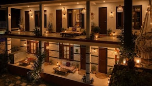 A two-story building with a balcony, outdoor seating area, and multiple light fixtures. - Elevn Stays, Manali (Manali)
