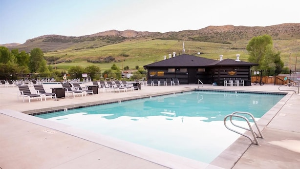 A swimming pool with lounge chairs and a building in the background.