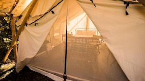 A tent with a bed and a table inside.