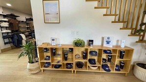 A store with a wooden display shelf filled with hats and a staircase to the right.