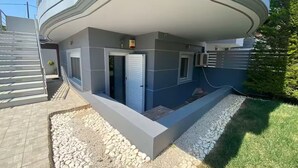 Un bâtiment moderne doté d’un toit plat, d’un espace extérieur couvert et d’une petite fenêtre.