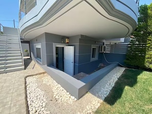 A modern building with a flat roof, a covered outdoor area, and a small window. - Quiet apartment in Artemis, Athens Airport (Artemis)