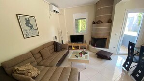 Un salon avec un canapé, une table basse, une cheminée et un téléviseur.