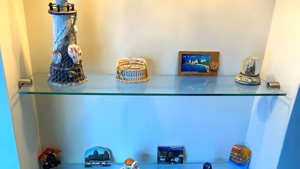 Une collection d’objets de collection exposée sur des étagères en verre.
