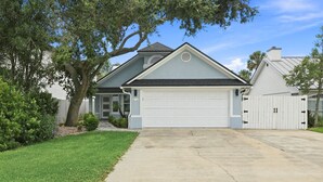 A residential house with a garage, a driveway, and a well-maintained lawn. - Modern 3BR Near Beach | Good Morning Rentals (Jacksonville Beach)