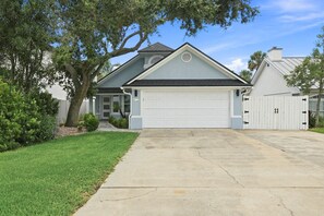 Ein Wohnhaus mit Garage, Auffahrt und gepflegtem Rasen.