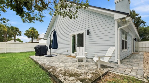 A house with a covered patio area, a grill, and outdoor seating. - Modern 3BR Near Beach | Good Morning Rentals (Jacksonville Beach)