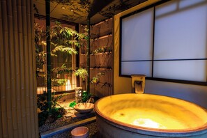 A traditional Japanese-style room with a tatami mat floor, a large wooden bathtub, and bamboo plants. - Konjaku-so Osaka Dotonbori - Bookstore - (大阪市中央区道頓堀１丁目東)