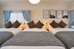 A hotel room with a large bed, two bedside tables, a wall with framed pictures, and blue curtains. - EH-KOBAI06 (Osakashi kitaku kobaicho)