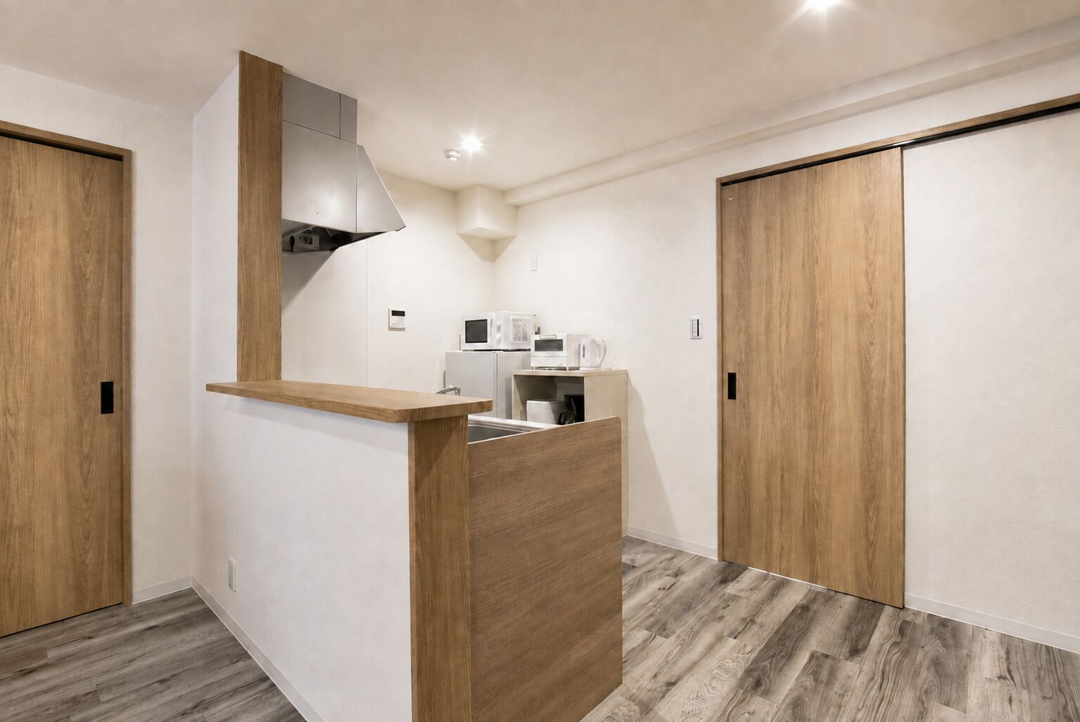 A modern kitchen with a built-in microwave, a coffee maker, and a wooden counter.
