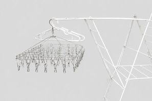 A metal drying rack with multiple pegs and a hanging clothes hanger. - EH-KOBAI06 (Osakashi kitaku kobaicho)