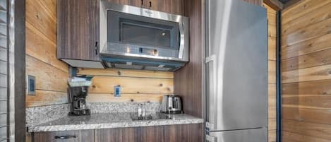 A compact kitchen with a microwave, toaster, and refrigerator.