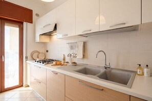 A modern kitchen with a double sink, stainless steel appliances, and light-colored cabinetry. - ALL MareVista | 5-Bedroom Coastal Retreat with Sea-View Terrace (Bari)