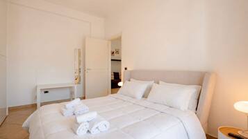 Une chambre d’hôtel avec un lit, un bureau et une lampe.