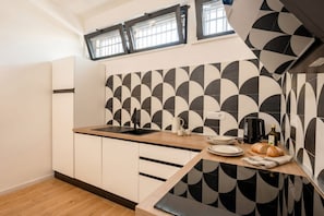 A modern kitchen with a geometric tile backsplash, a wooden countertop, and a built-in oven. - ALL MareVista | 5-Bedroom Coastal Retreat with Sea-View Terrace (Bari)