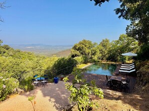 A patio area with a pool, outdoor seating, and a view of the landscape. - Le Bastidon (La Garde-Freinet)