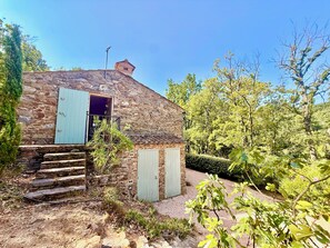 A stone cottage with a wooden door and steps leading to a porch. - Le Bastidon (La Garde-Freinet)