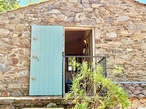 A stone building with a blue door and a small balcony. - Le Bastidon (La Garde-Freinet)