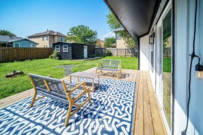 Una terraza con mobiliario exterior y un tapete estampado.