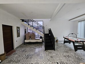Ein Zimmer mit einem gemusterten Boden, einer Couch, einem Tisch und einer Treppe.