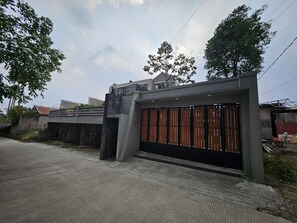Ein verschlossenes Tor mit einer Betonstruktur, einem Metallgitter und einem kleinen Balkon.