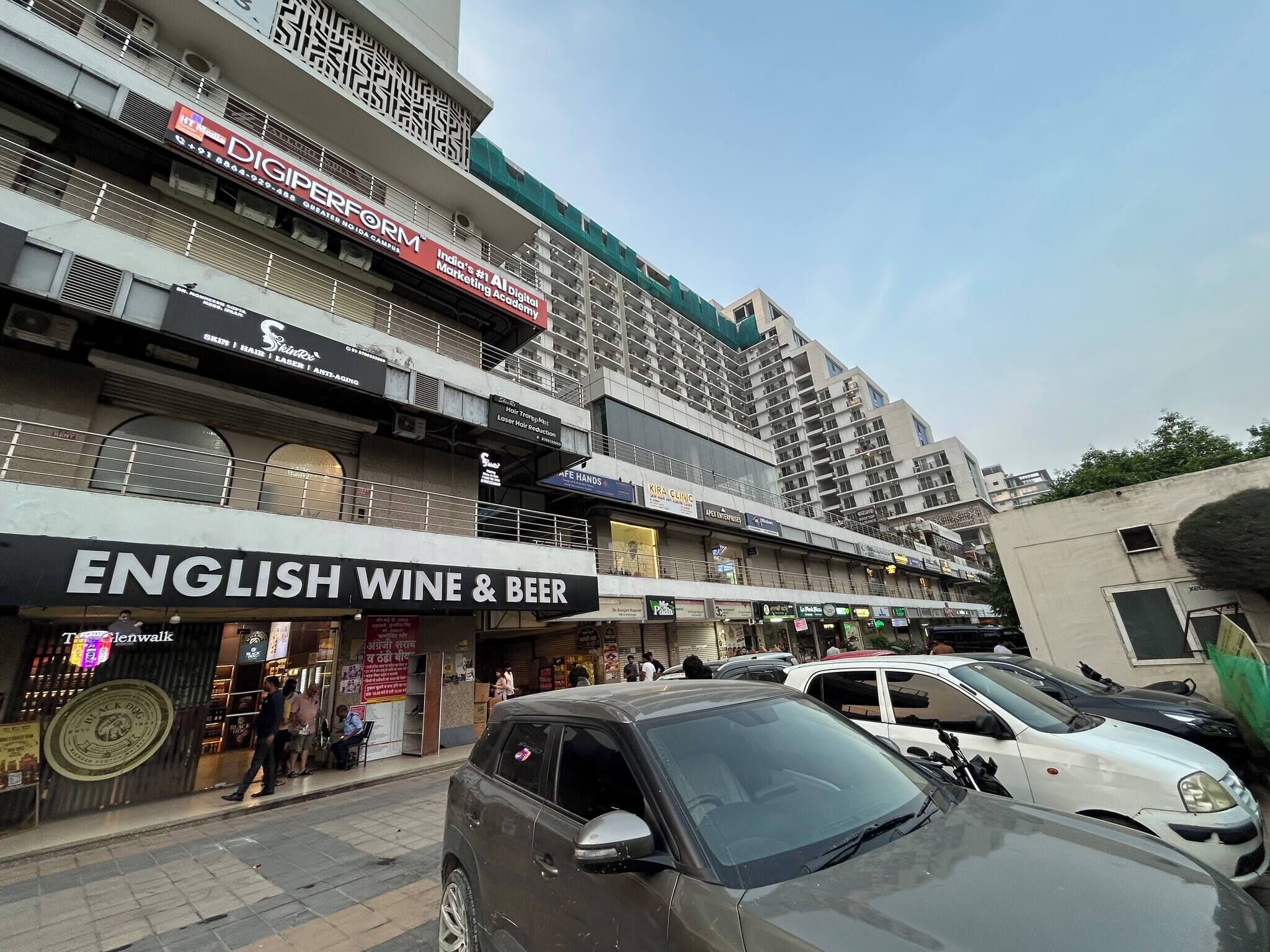 Un edificio comercial de varios pisos con diversas tiendas en la planta baja, incluyendo una licorería inglesa.