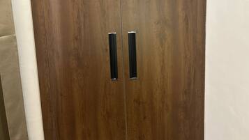 Un amplio armario de madera con dos puertas y un tirador central.