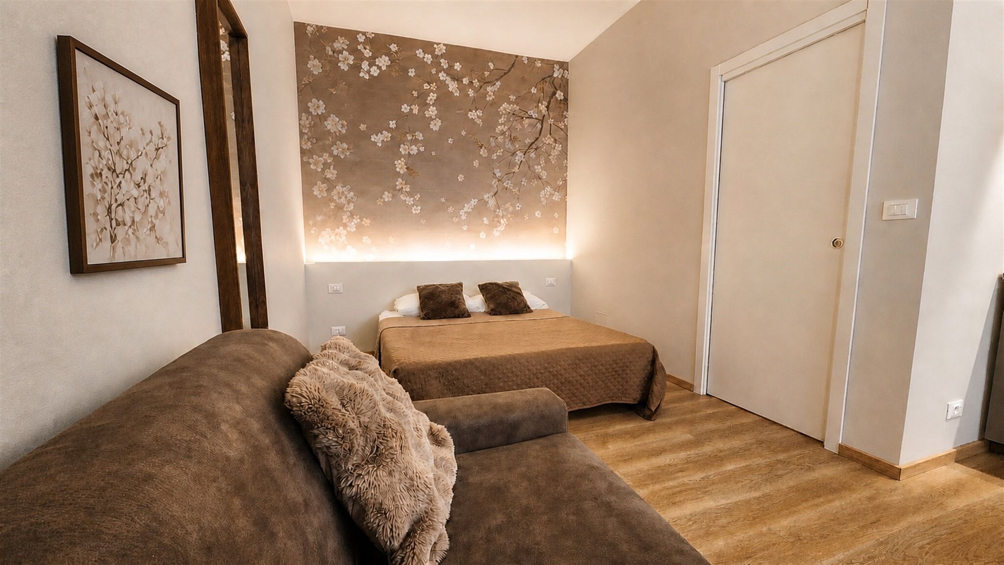 Une chambre avec deux lits, une grande œuvre d’art accrochée au mur et une porte.