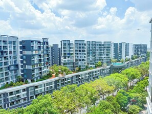 Ett modernt bostadskomplex med flera höga hyreshus, en central gånggata och omgivande grönska.
