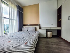 A modern hotel room with a large bed, a desk, and a wardrobe. - Luxury 3BR at Diamond Alnata Pool & Gym - Next to Aeon Mall, Park & SGN (Tân Phú)