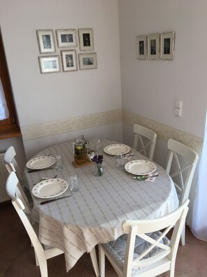 A dining table set for four with white plates and glasses, surrounded by white chairs. - Spacious 3-bedroom apartment in tranquil Cserszegtomaj, Balaton view, pool, AC (Cserszegtomaj)
