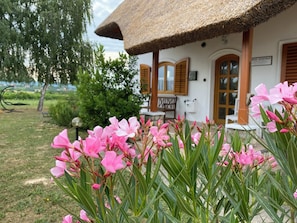 A house with a thatched roof, wooden shutters, and a sign indicating a restaurant. - Spacious 3-bedroom apartment in tranquil Cserszegtomaj, Balaton view, pool, AC (Cserszegtomaj)