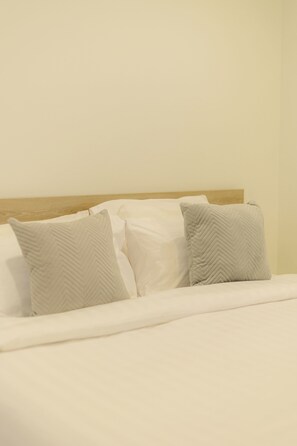 A neatly made bed with white linens and two pillows with a chevron pattern. - Terrific 1-bedroom condo with AC in charming Chiang Mai (Chiang Mai)