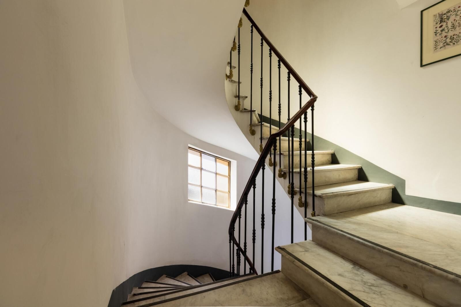 Una escalera con una pared curva y una ventana.