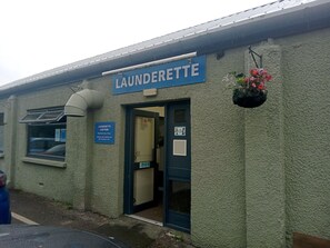 A laundrette with a sign, a window, and a door. - Beautiful Caravan minutes from Cartmel & Grange-over-Sands, Lakes are nearby. (Flookburgh)